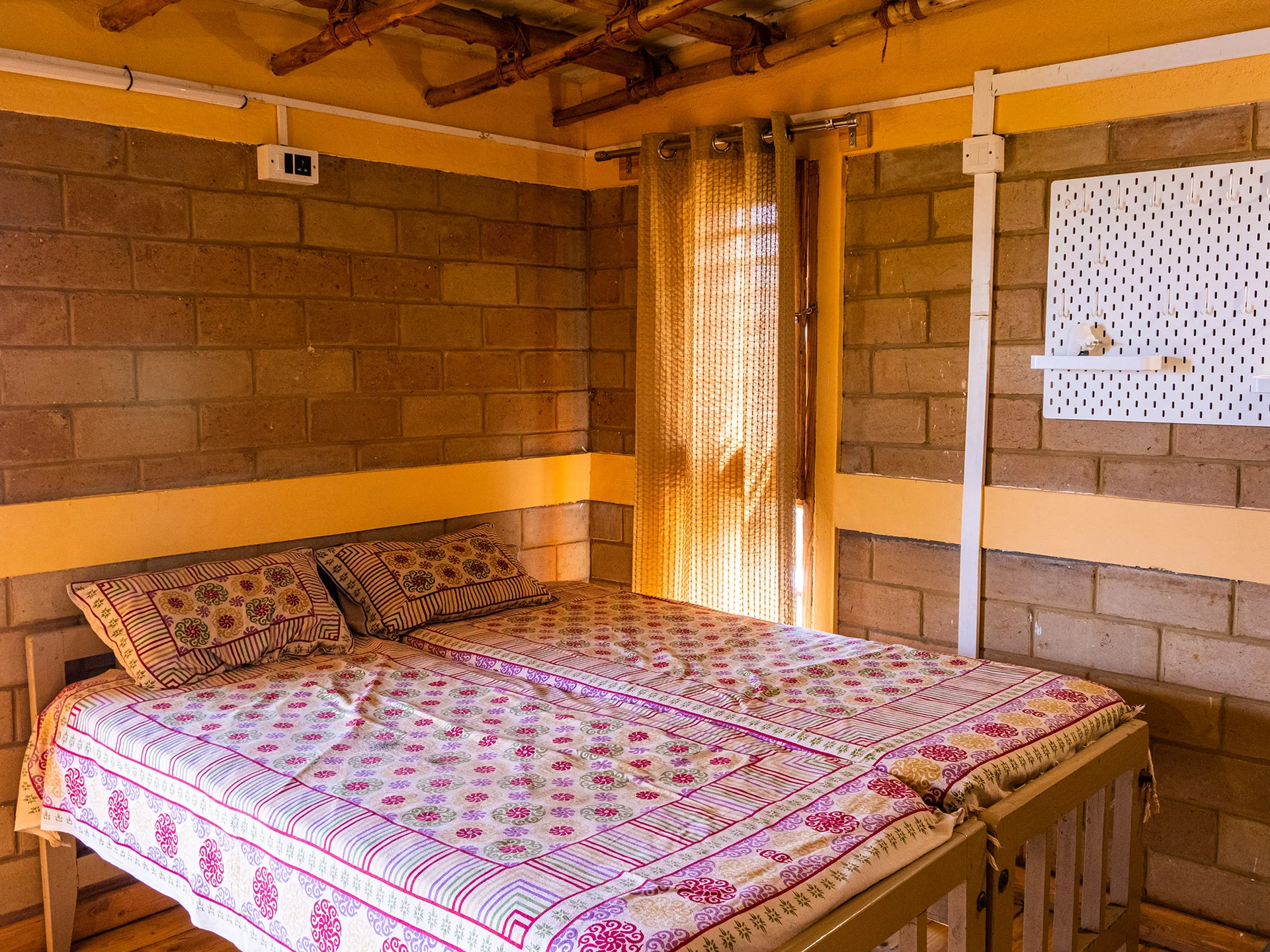 Beds beneath the exposed wooden ceiling at Fortitude.